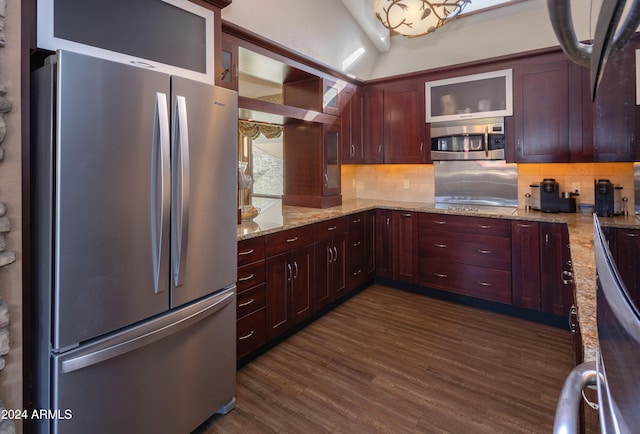 kitchen with backsplash, light stone countertops, dark hardwood / wood-style flooring, and stainless steel appliances