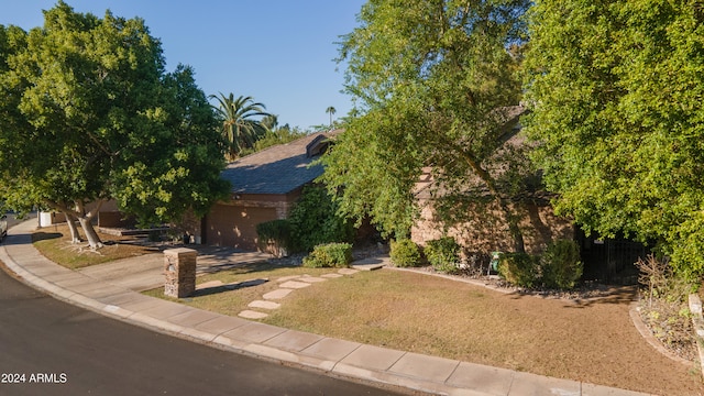 obstructed view of property with a garage and a front lawn