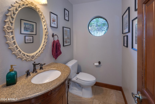 bathroom featuring toilet, vanity, and tile patterned flooring