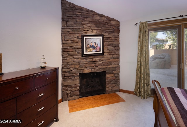 unfurnished bedroom featuring lofted ceiling, light colored carpet, and a fireplace