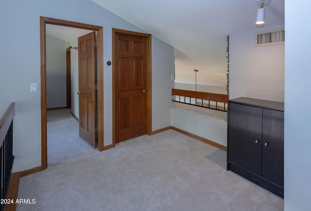 corridor featuring carpet flooring and lofted ceiling