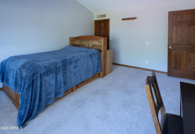 bedroom featuring light carpet and lofted ceiling