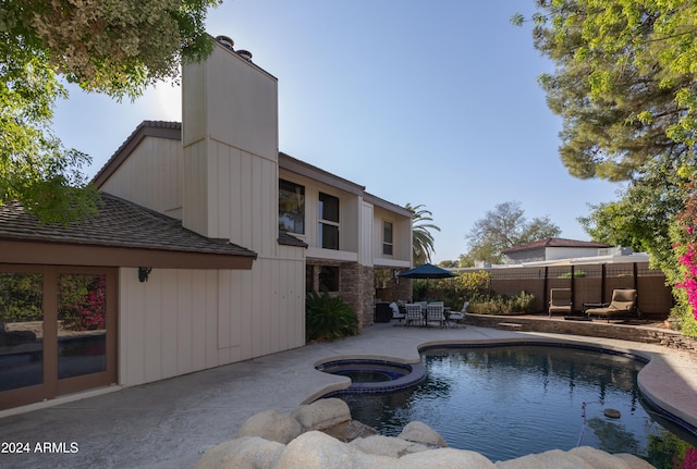 view of swimming pool with a patio area and an in ground hot tub