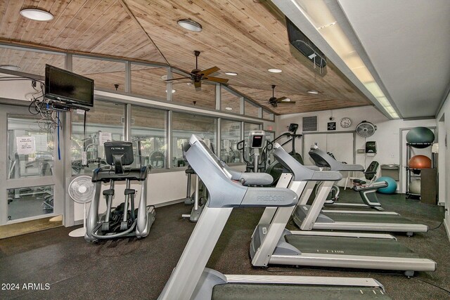 exercise room with vaulted ceiling and wood ceiling