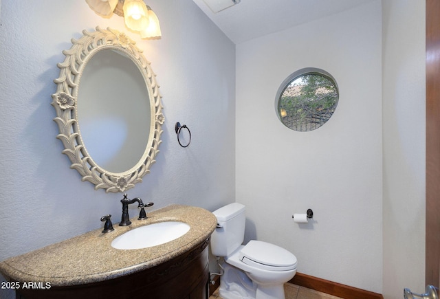 bathroom featuring toilet, vanity, and tile patterned flooring