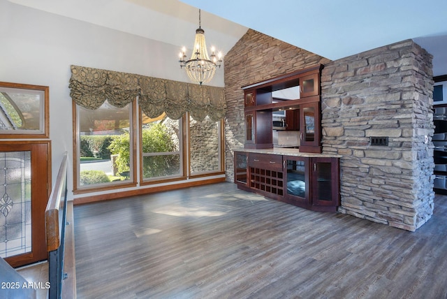 living room with lofted ceiling, dark hardwood / wood-style flooring, and an inviting chandelier