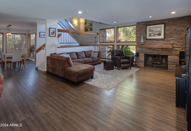 living room featuring dark hardwood / wood-style floors and a stone fireplace