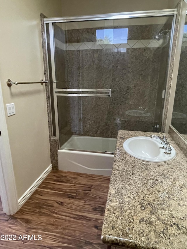 bathroom featuring vanity, combined bath / shower with glass door, and wood-type flooring