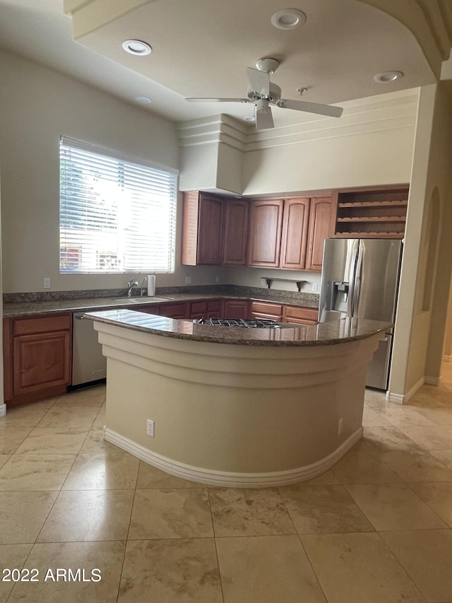kitchen featuring ceiling fan, dark stone countertops, light tile patterned floors, and stainless steel refrigerator with ice dispenser