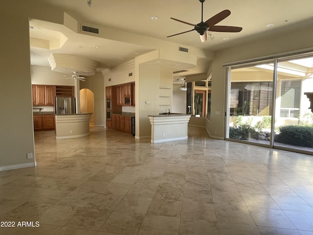 unfurnished living room featuring a high ceiling and ceiling fan