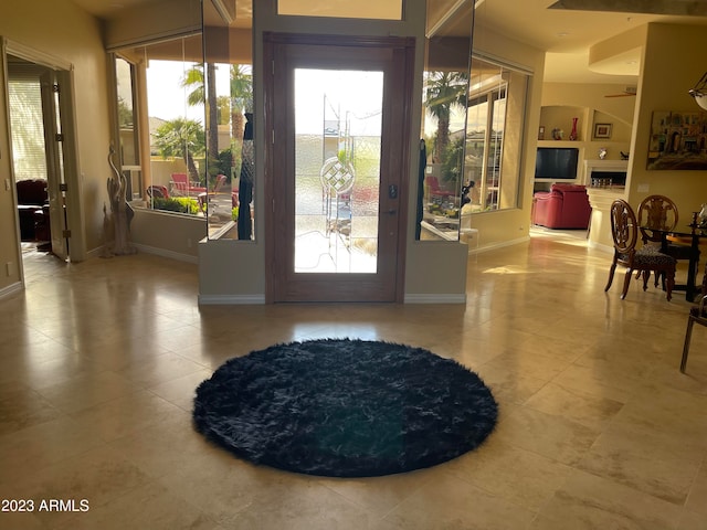 doorway featuring tile patterned floors, ceiling fan, and built in features
