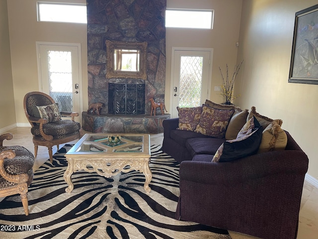 living room featuring a stone fireplace and plenty of natural light