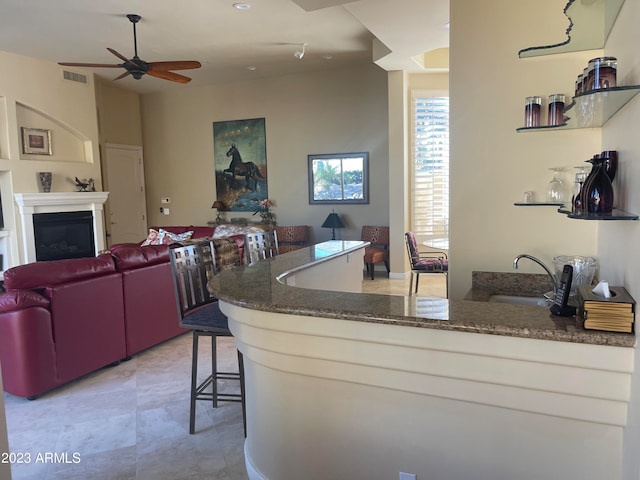 kitchen with a kitchen breakfast bar, ceiling fan, and sink