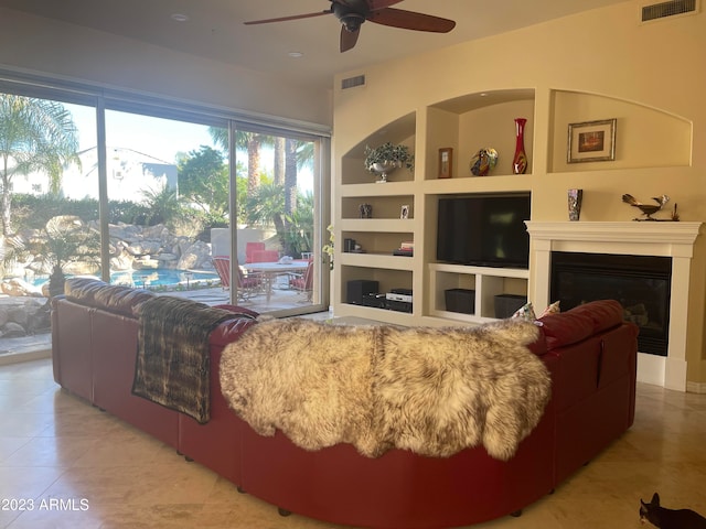 living room featuring built in features and ceiling fan