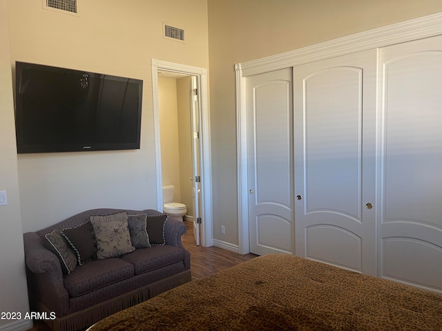 bedroom featuring ensuite bath and hardwood / wood-style flooring