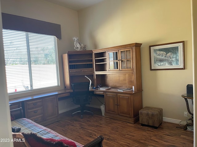 home office with built in desk and dark wood-type flooring