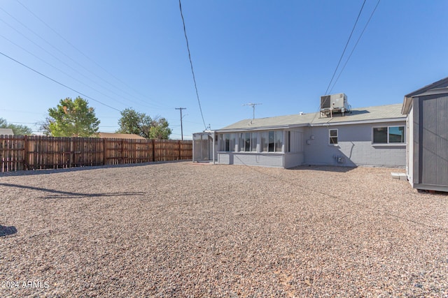 back of property with central air condition unit, a patio, and a sunroom