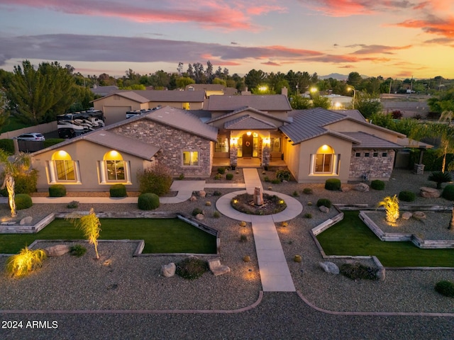mediterranean / spanish-style home featuring a yard, stone siding, and stucco siding