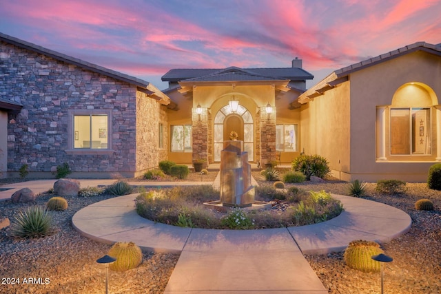view of front of house with stucco siding and stone siding