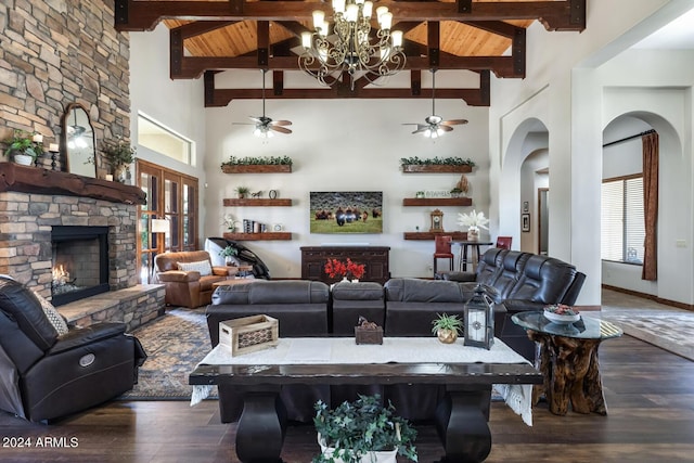 living room with a stone fireplace, wood finished floors, and ceiling fan with notable chandelier