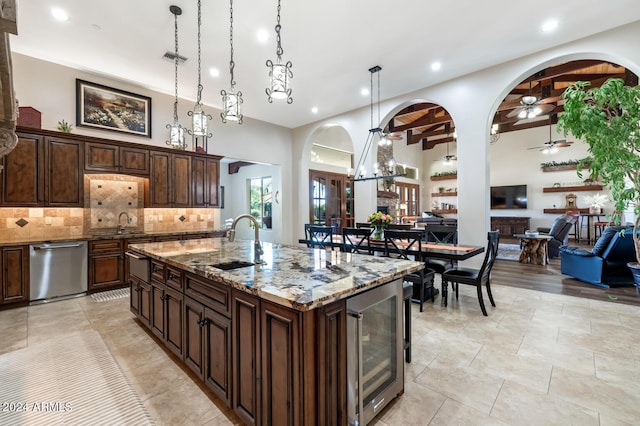 kitchen with stainless steel dishwasher, decorative backsplash, wine cooler, ceiling fan, and a sink