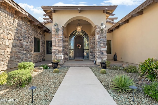 view of exterior entry with stucco siding and stone siding