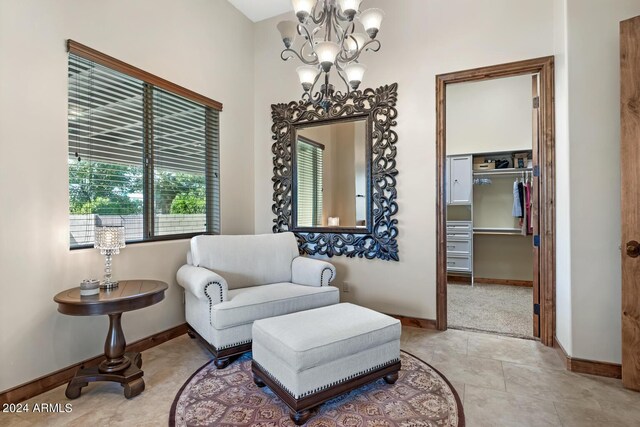 living area with baseboards, light tile patterned floors, and a notable chandelier