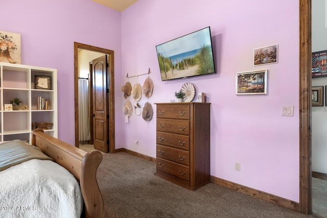 carpeted bedroom featuring connected bathroom and baseboards