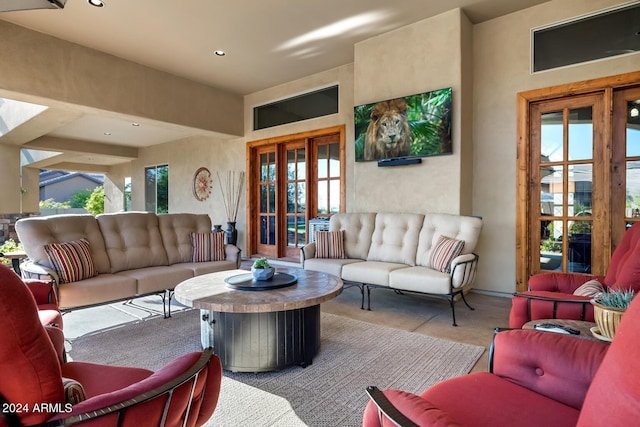 living area with recessed lighting, concrete floors, and french doors