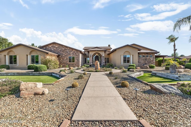 mediterranean / spanish home with a front lawn and stucco siding