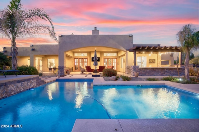 pool with french doors, a patio, and a pergola