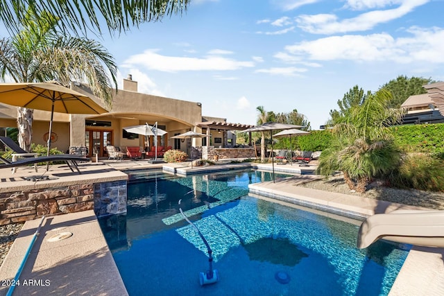 outdoor pool featuring french doors, a water slide, and a patio