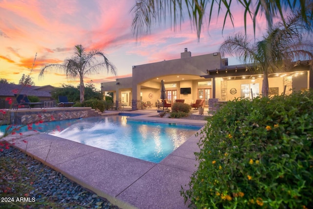 pool with a patio area and french doors