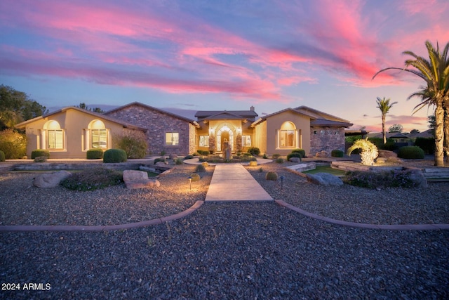 mediterranean / spanish-style home featuring stucco siding and stone siding