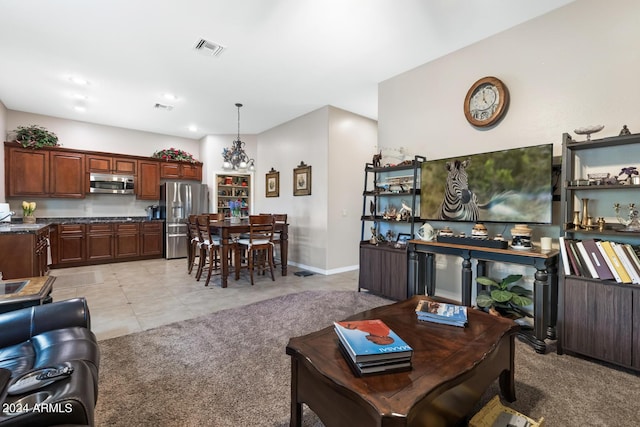 living area featuring light colored carpet, baseboards, visible vents, and light tile patterned floors