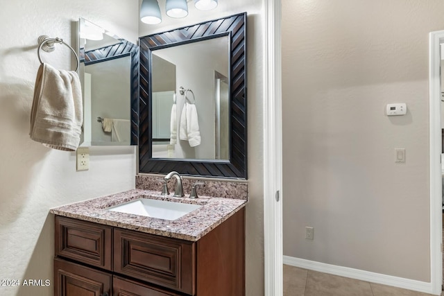 bathroom featuring baseboards, tile patterned flooring, and vanity