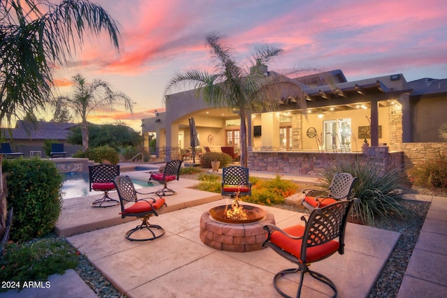 view of patio featuring an outdoor pool and an outdoor fire pit