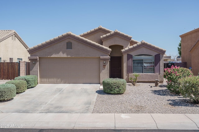 10618 W Pima St, Tolleson, AZ 85353 - view of front of property with a garage, stucco siding, driveway, and a tiled roof