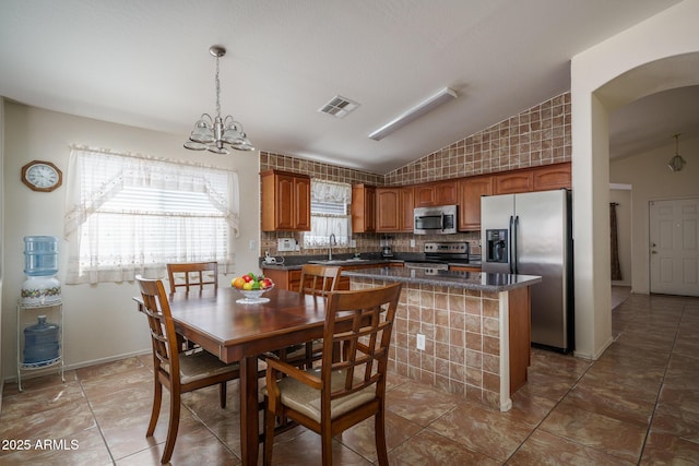 10618 W Pima St, Tolleson, AZ 85353 - tiled dining area featuring vaulted ceiling, a chandelier, and arched walkways