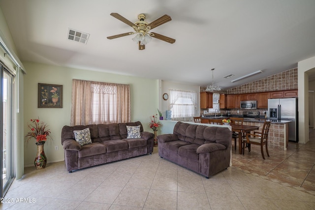 10618 W Pima St, Tolleson, AZ 85353 - living area featuring vaulted ceiling, a ceiling fan, healthy amount of natural light, light tile patterned floors, and a chandelier