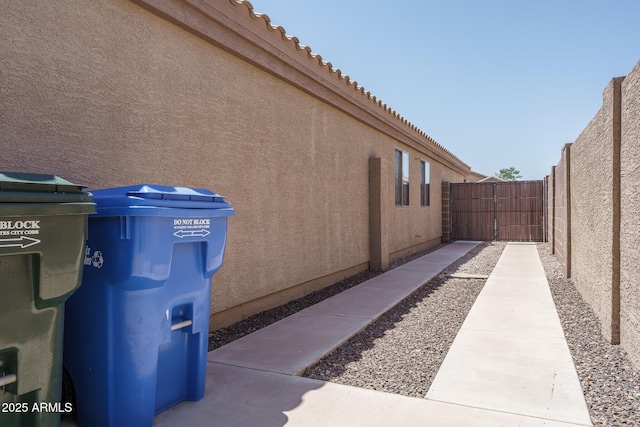 10618 W Pima St, Tolleson, AZ 85353 - view of home's exterior featuring stucco siding, a tiled roof, and a gate
