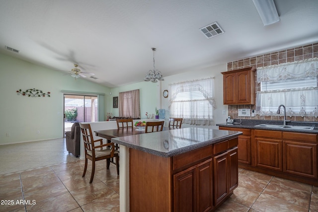 10618 W Pima St, Tolleson, AZ 85353 - kitchen with vaulted ceiling, a center island, ceiling fan, a chandelier, and pendant lighting
