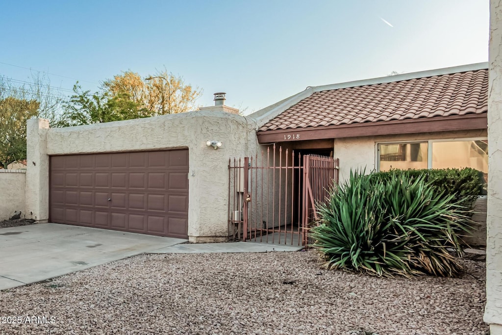 1918 S Shannon Dr, Tempe, AZ 85281 - view of front of property featuring stucco siding, a gate, fence, a garage, and a tile roof