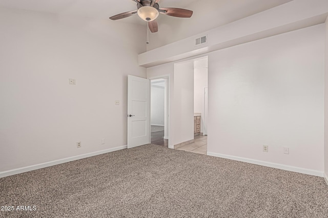 unfurnished bedroom featuring light colored carpet, ceiling fan, baseboards, visible vents, and high vaulted ceiling