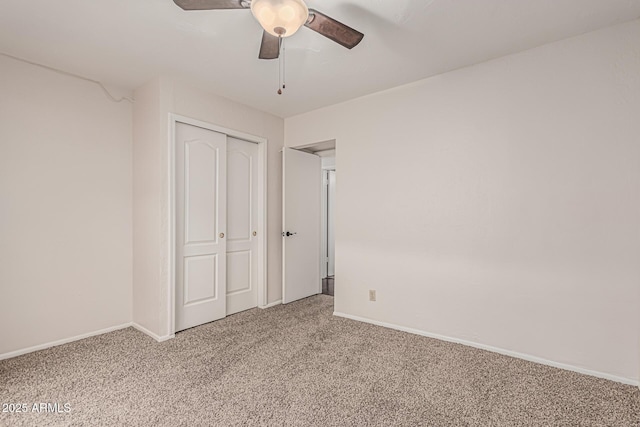 unfurnished bedroom with a closet, carpet flooring, a ceiling fan, and baseboards