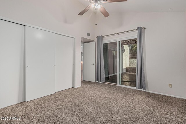 unfurnished bedroom featuring access to outside, a closet, carpet, visible vents, and lofted ceiling