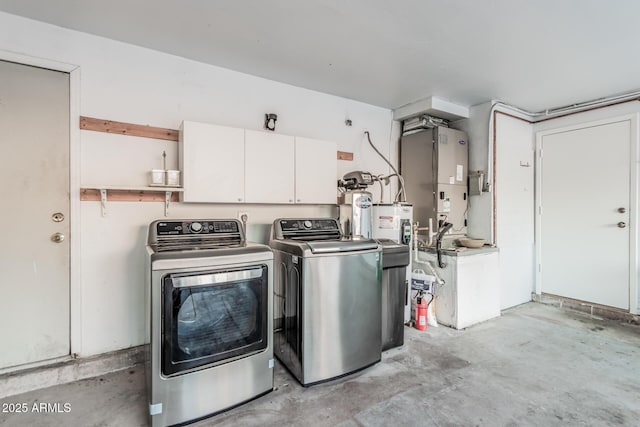 laundry area with independent washer and dryer and cabinet space