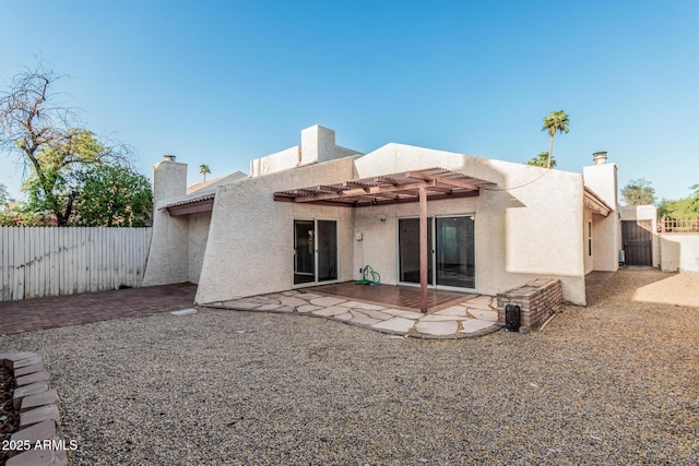 rear view of property with fence, a patio area, stucco siding, and a pergola