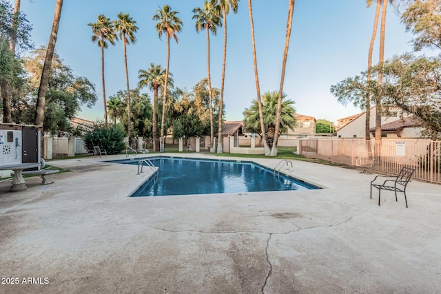 community pool with a patio and fence