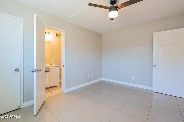 unfurnished bedroom featuring ceiling fan, connected bathroom, and light tile patterned flooring